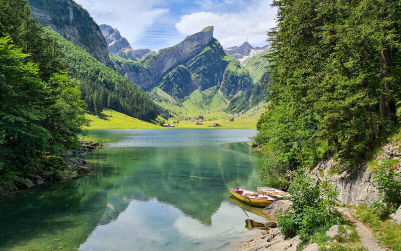 “Crystal-clear waters of Lake Seealpsee nestled in the Alpstein Alps, Switzerland.”