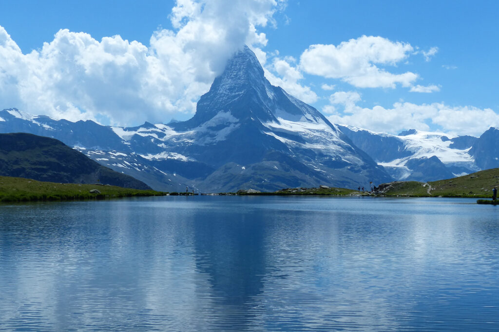 Snow‑capped Matterhorn peak rising above alpine meadows at dawn, Valais, Switzerland.