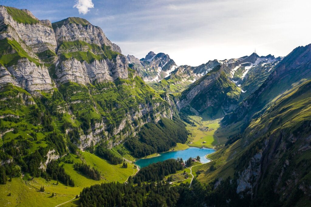 “The iconic Äscher mountain guesthouse built into the rock face in the Alpstein, Switzerland.”