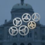 A conceptual, photorealistic graphic showing seven equal, interlocked gears resembling a clockwork mechanism, with one gear subtly glowing. This represents the Swiss Federal Council's 'Konkordanz' model, emphasizing collective leadership, precision, and the symbolic rotation of the Presidency.